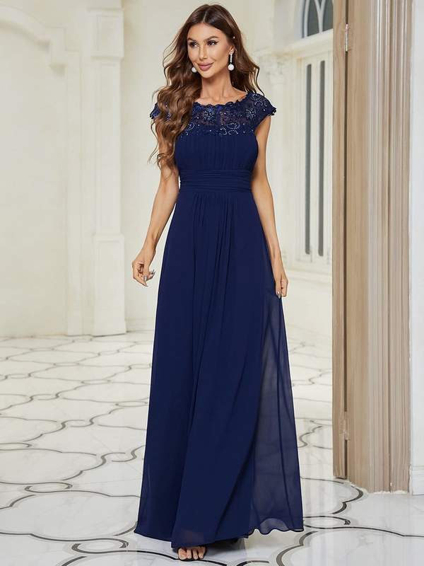 Woman wearing Allanah cap sleeve lace and chiffon bridesmaid dress in navy